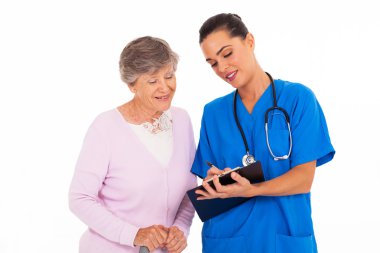 dostu genç hemşire kadın kıdemli tıbbi formu ile yardım