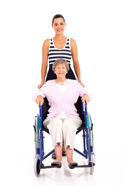 Erwachsene Enkelin schubst behinderte Seniorin im Rollstuhl — Stockfoto
