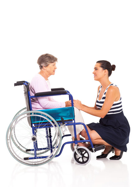 Loving daughter talking to disabled senior mother on white background