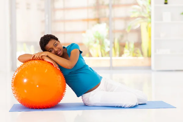 Jeune femme africaine enceinte avec ballon d'exercice à la maison — Photo