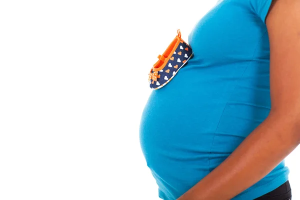 Babyskor på gravid afroamerikanska kvinna mage — Stockfoto