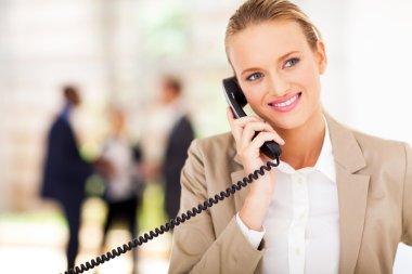 güzel iş kadını ofiste sabit telefonu konuşurken