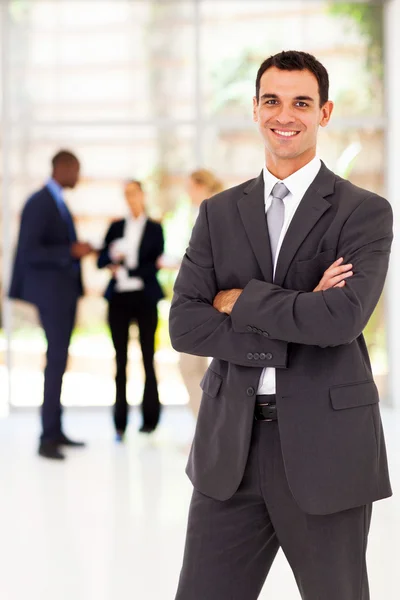 Bonito empresário braços dobrado retrato no escritório — Fotografia de Stock