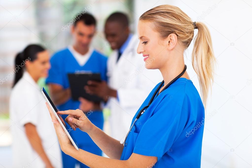 attractive young medical nurse using tablet computer