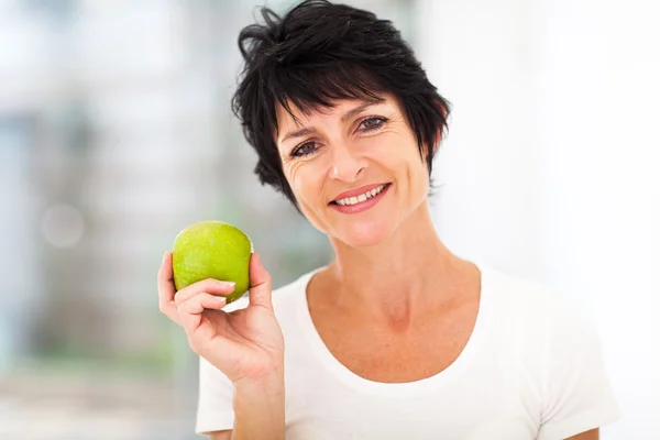 Kvinna som håller i ett grönt äpple — Stockfoto