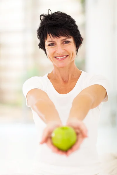 Kvinna som håller i ett grönt äpple — Stockfoto