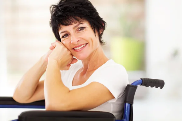Mulher de meia idade sentada em cadeira de rodas — Fotografia de Stock