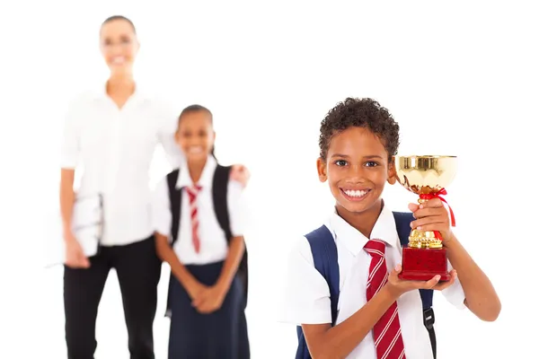 Lindo colegial sosteniendo trofeo delante del maestro y compañero de clase — Foto de Stock