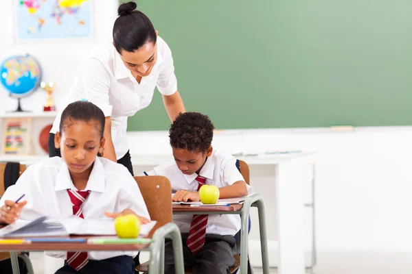 Cuidado del maestro de escuela primaria y los estudiantes en el aula — Foto de Stock