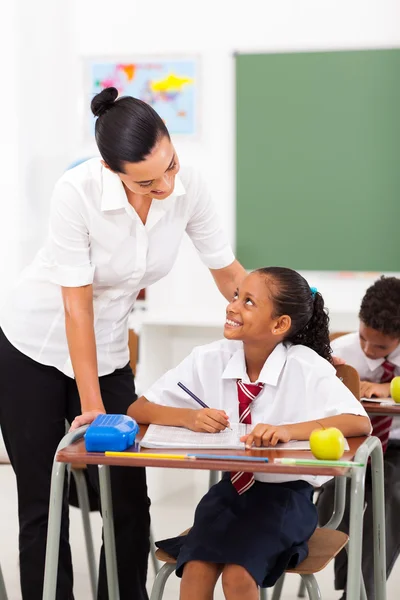 Vänlig kvinnlig lärare pratar med eleven i klassrummet — Stockfoto