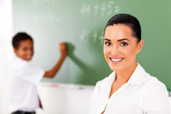 Muito elementar professor e estudante na frente do quadro — Fotografia de Stock