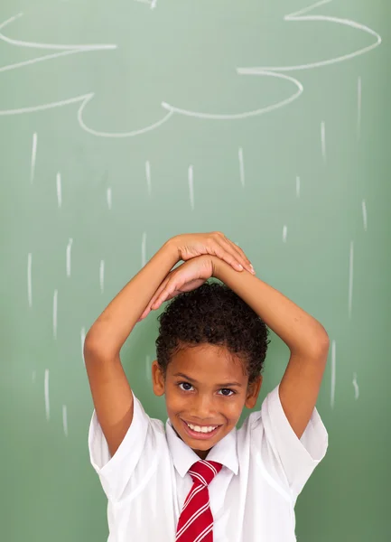 Estudante do ensino fundamental na frente da nuvem de chuva desenhada em quadro-negro — Fotografia de Stock