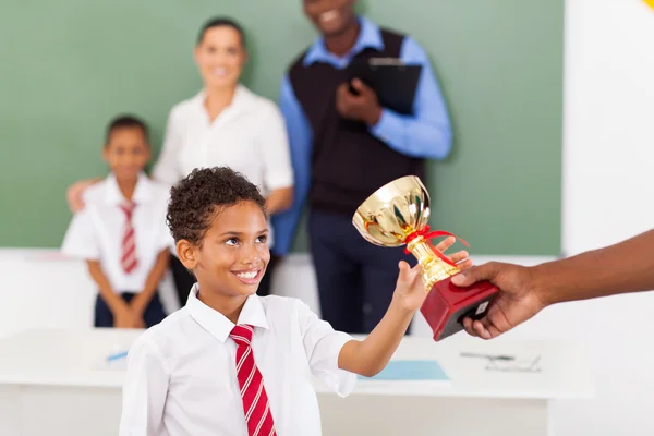 School boy receiving a trophy in classroom — Stock Photo, Image