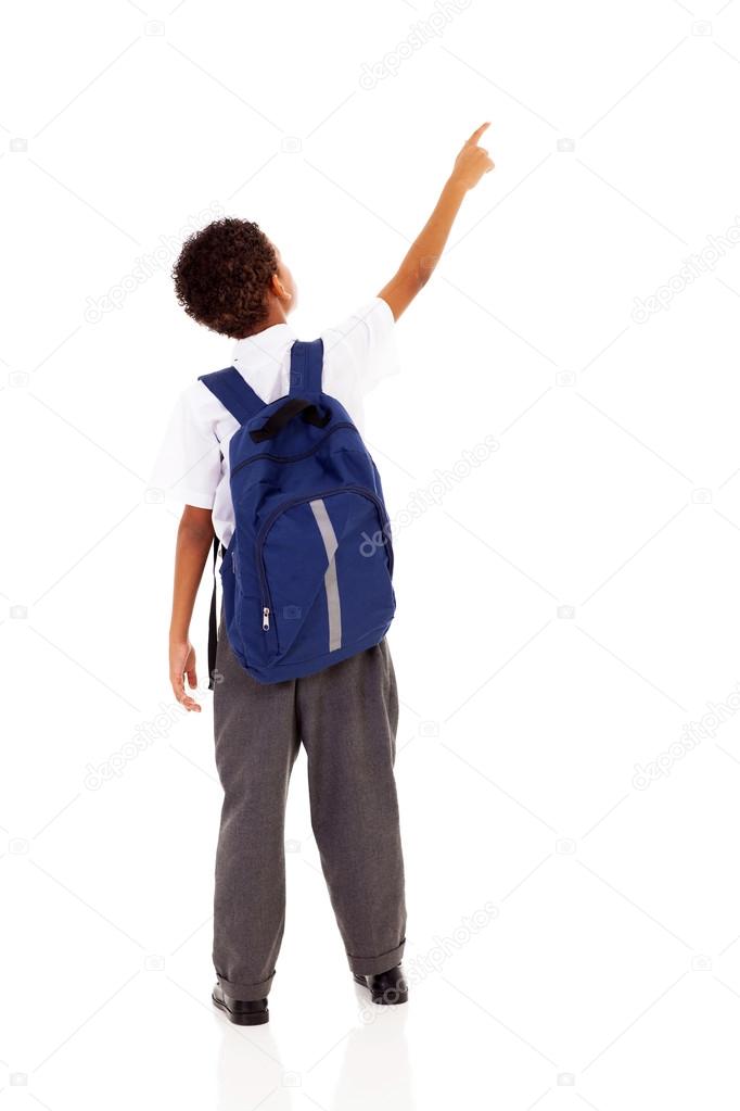 Little schoolboy with schoolbag pointing at empty copy space