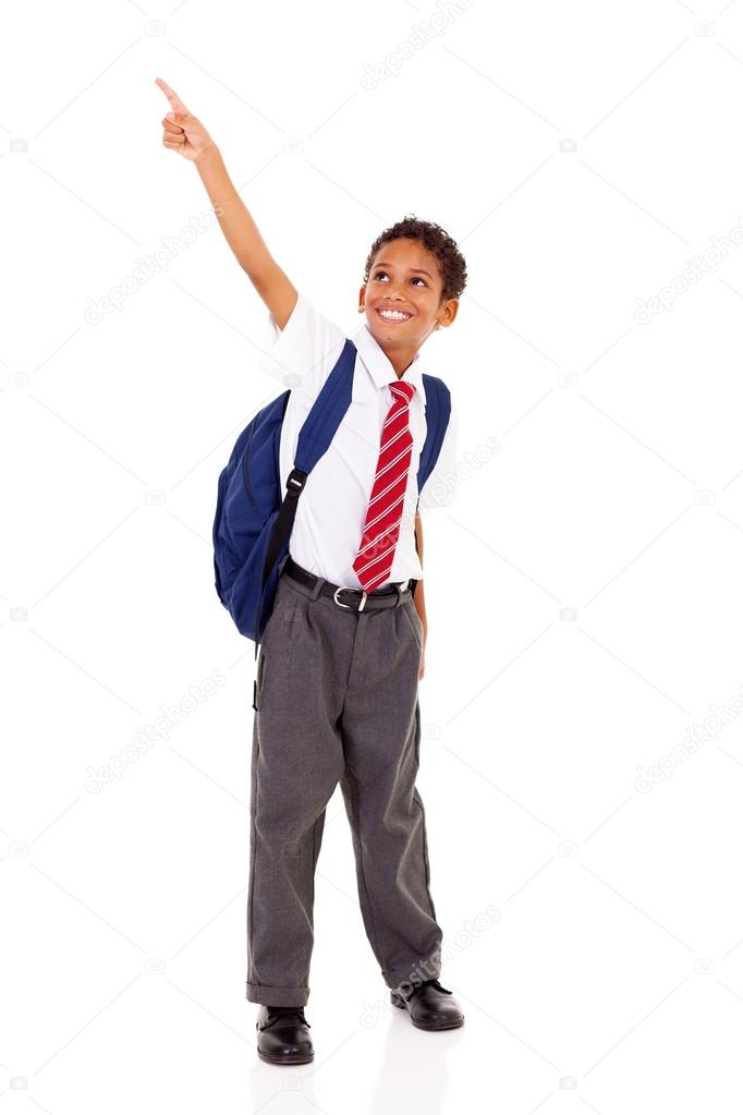 Primary schoolboy pointing at empty copyspace isolated on white