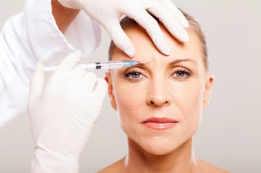 Cosmetic surgeon giving face lifting injection clipart