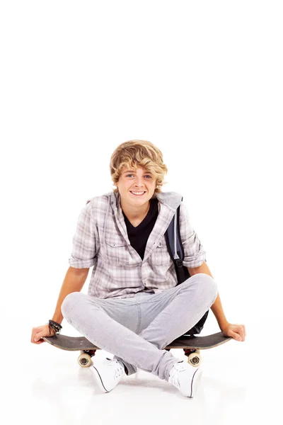 Bonito adolescente menino sentado no skate — Fotografia de Stock