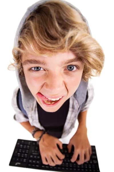 Overhead-Ansicht eines frechen Teenager-Jungen, der auf der Computertastatur spielt — Stockfoto