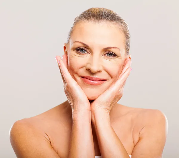 Pretty senior woman with hands on her face — Stock Photo, Image