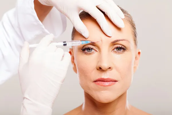 Cosmetic surgeon giving face lifting injection — Stock Photo, Image