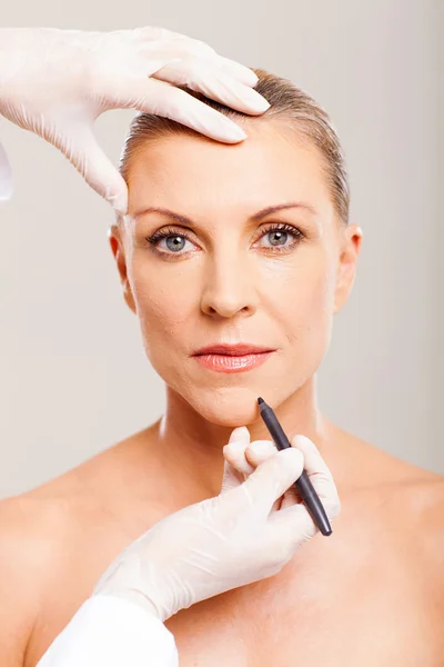 Cosmetic surgeon marking mid age woman — Stock Photo, Image