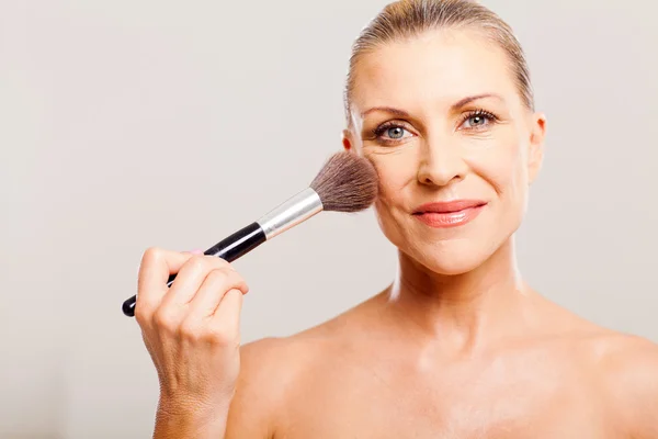 Schöne reife Frau, die Make-up aufträgt — Stockfoto