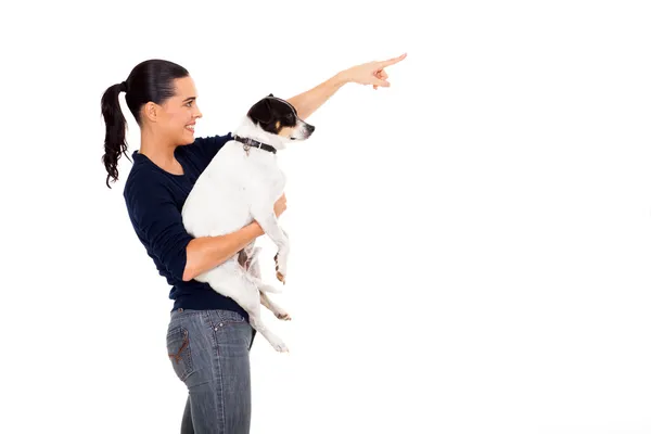 Happy woman holding dog and pointing — Stock Photo, Image