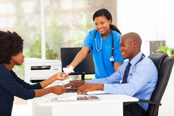 Vårdande afrikanska sjuksköterska överlämnandet vävnad — Stockfoto