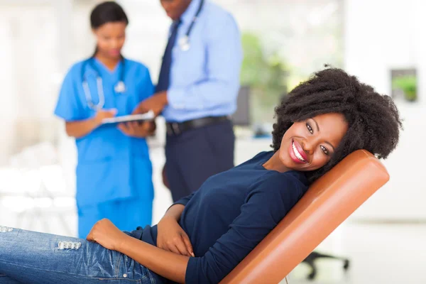 Happy african woman waiting for medical checkup — Stock Photo, Image