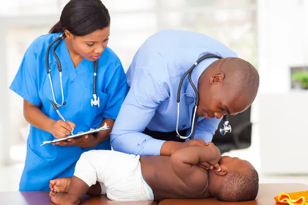 Doctor y enfermera haciendo chequeo de niño pequeño — Foto de Stock