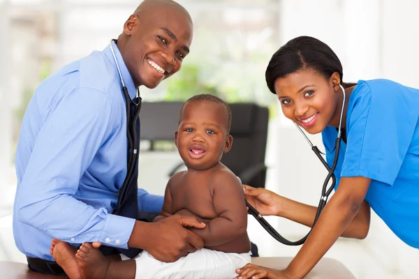 Enfermeira examinando menino com médico masculino — Fotografia de Stock