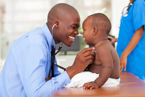 Africano médico masculino examinando bebé niño — Foto de Stock