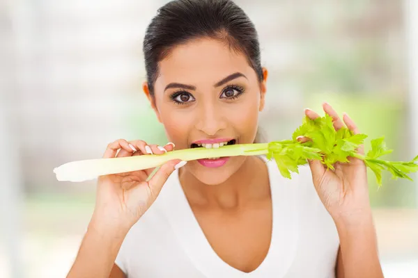 Mujer joven comiendo un palo de apio — Foto de Stock