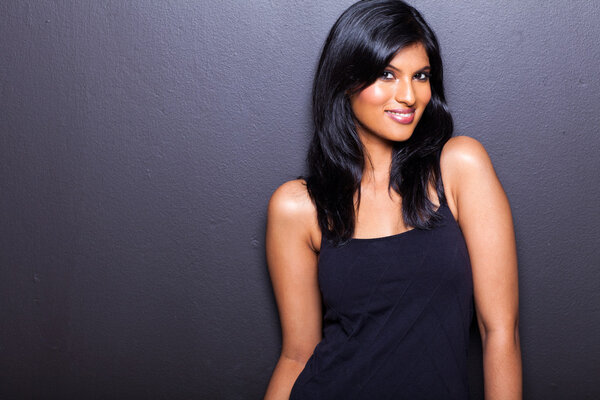 привлекательная женская модель на черной стене
