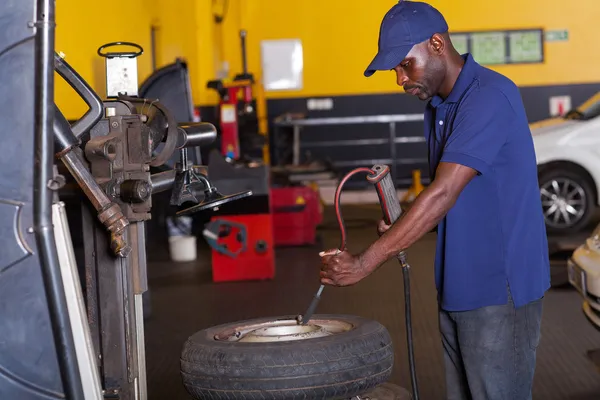 Mechaniker pumpt Autoreifen — Stockfoto