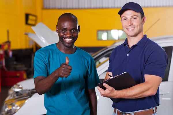 Cliente dando pulgar hacia arriba en el taller de reparación de automóviles — Foto de Stock