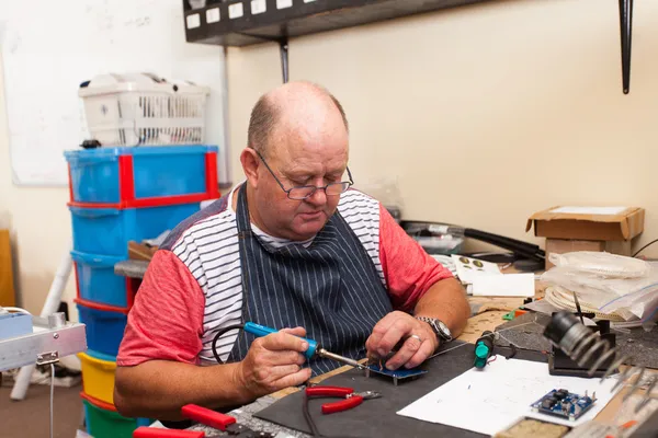 Hombre mayor que trabaja en el taller — Foto de Stock