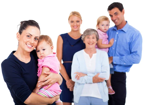 Jonge vrouw met haar baby met uitgebreide familie op achtergrond — Stockfoto