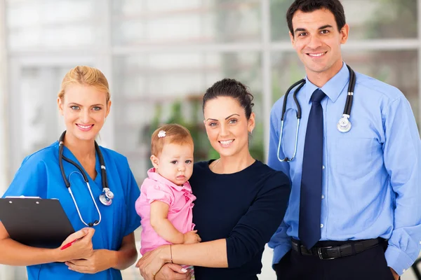 Woman holding her baby standing with doctor and female nurse Royalty Free Stock Images