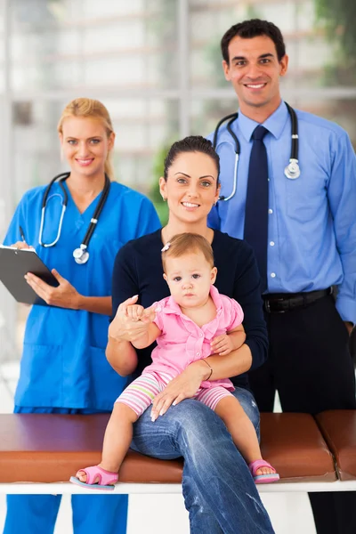 Happy mother taking baby girl for medical checkup Stock Photo