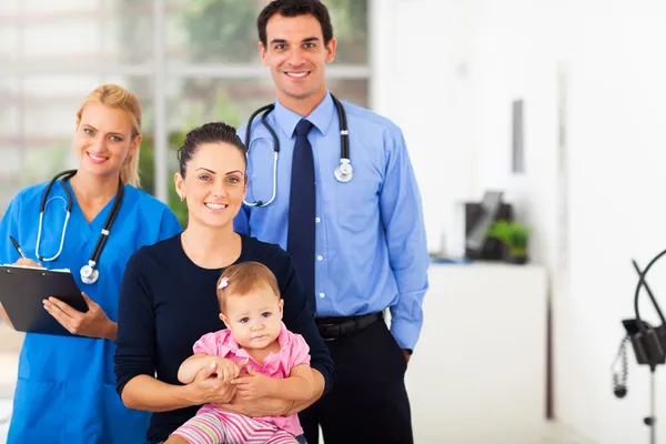 Medical professionals with mother and baby girl Stock Image
