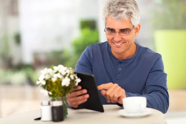 Homem de meia idade navegando na internet usando computador tablet — Fotografia de Stock
