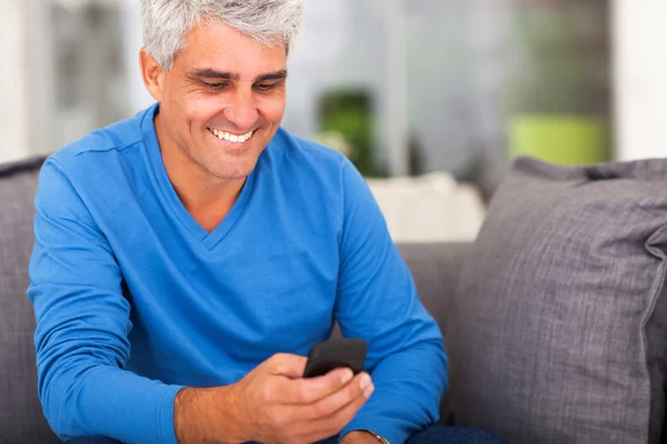 Hombre de mediana edad leyendo correos electrónicos en el teléfono inteligente —  Fotos de Stock