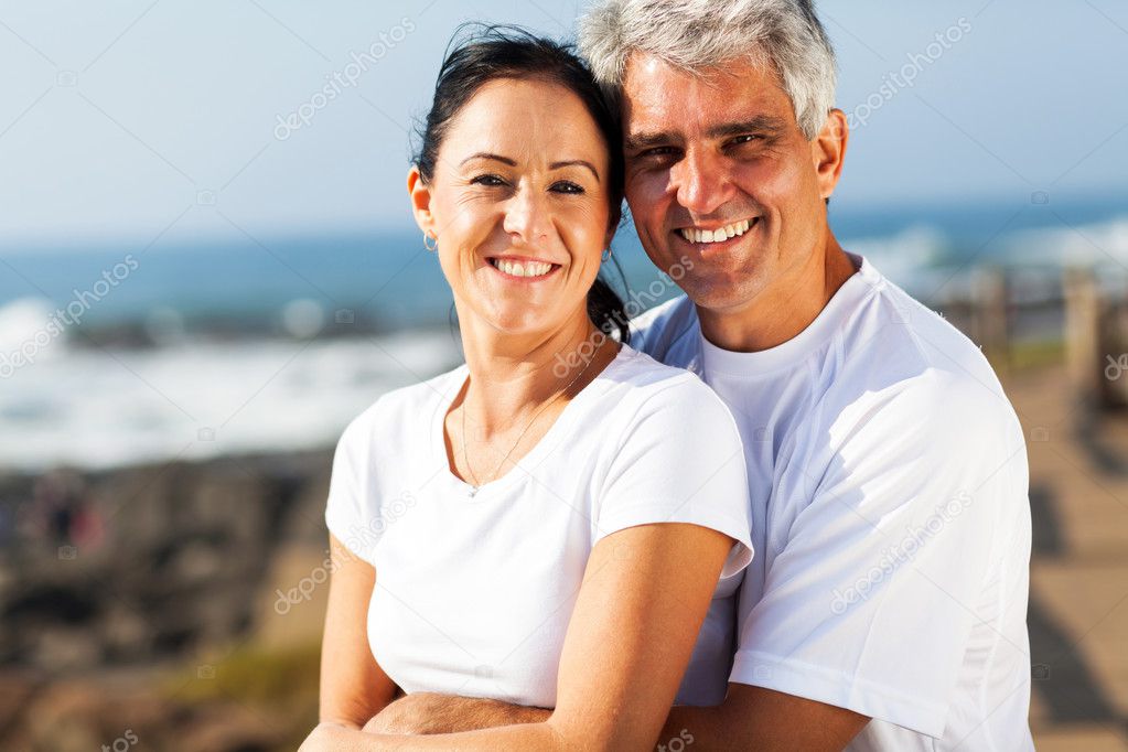 middle aged couple hugging at the beach