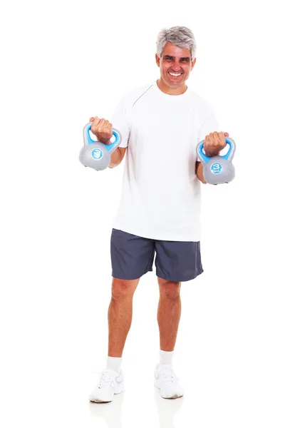 Homme d'âge moyen faisant de l'exercice avec des cloches bouilloire — Photo