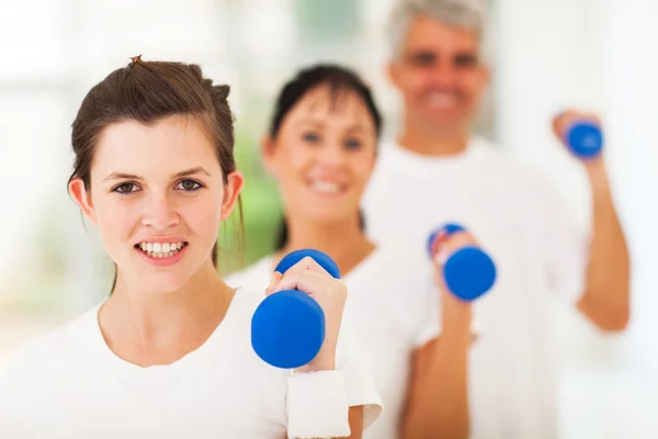 Teen daugther exercising using dumbbell with parents — Stock Photo, Image