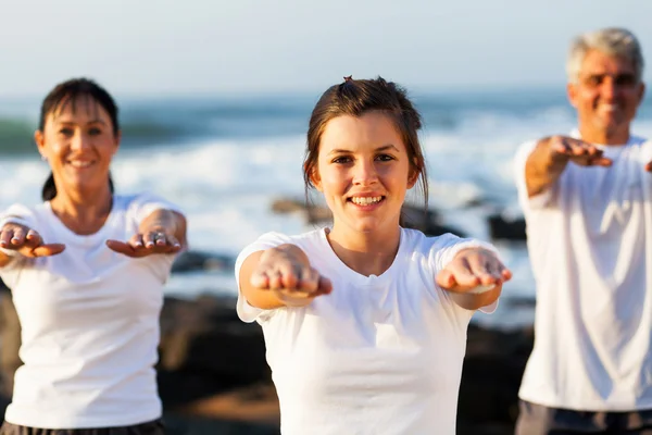 Young teen girl training her parents at the beach — Stock Photo, Image