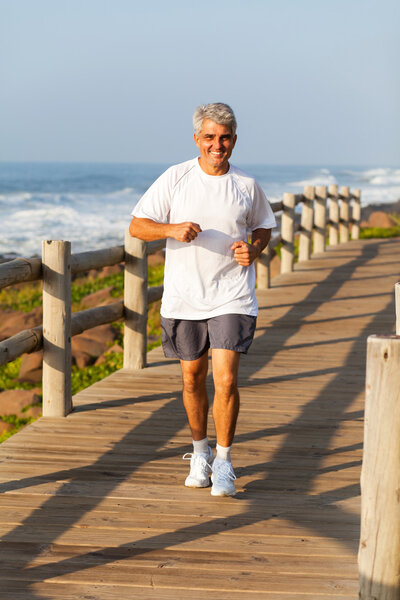 active middle aged man jogging at the beach