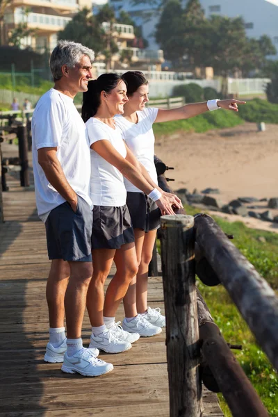 Tienerdochter wijzend op oceaan — Stockfoto