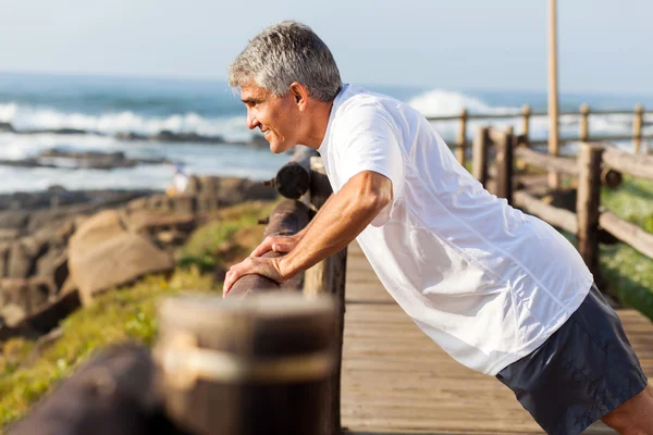 Hombre mayor en forma haciendo ejercicio en la playa — Foto de Stock